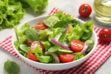 Photo of Delicious vegetable salad on light grey table, closeup