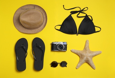 Photo of Flat lay composition with stylish beach accessories on yellow background