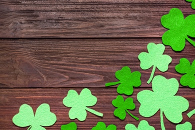 Flat lay composition with clover leaves on wooden background, space for text. St. Patrick's Day celebration