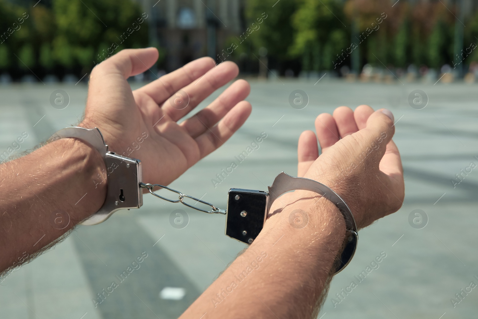 Photo of Man in handcuffs on city street, closeup