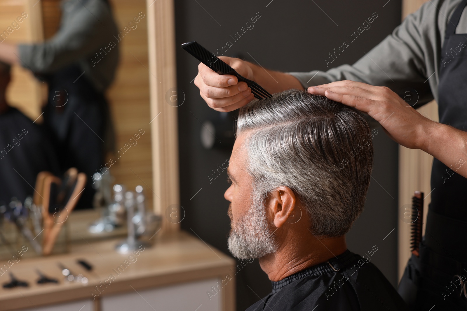 Photo of Hair styling. Professional hairdresser working with client in barbershop, closeup