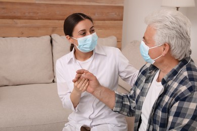 Doctor taking care of senior man with protective mask at nursing home