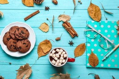Photo of Flat lay composition with cup of hot drink on blue wooden table. Cozy autumn atmosphere