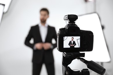 Handsome model posing for camera in modern studio, selective focus. Professional photo session