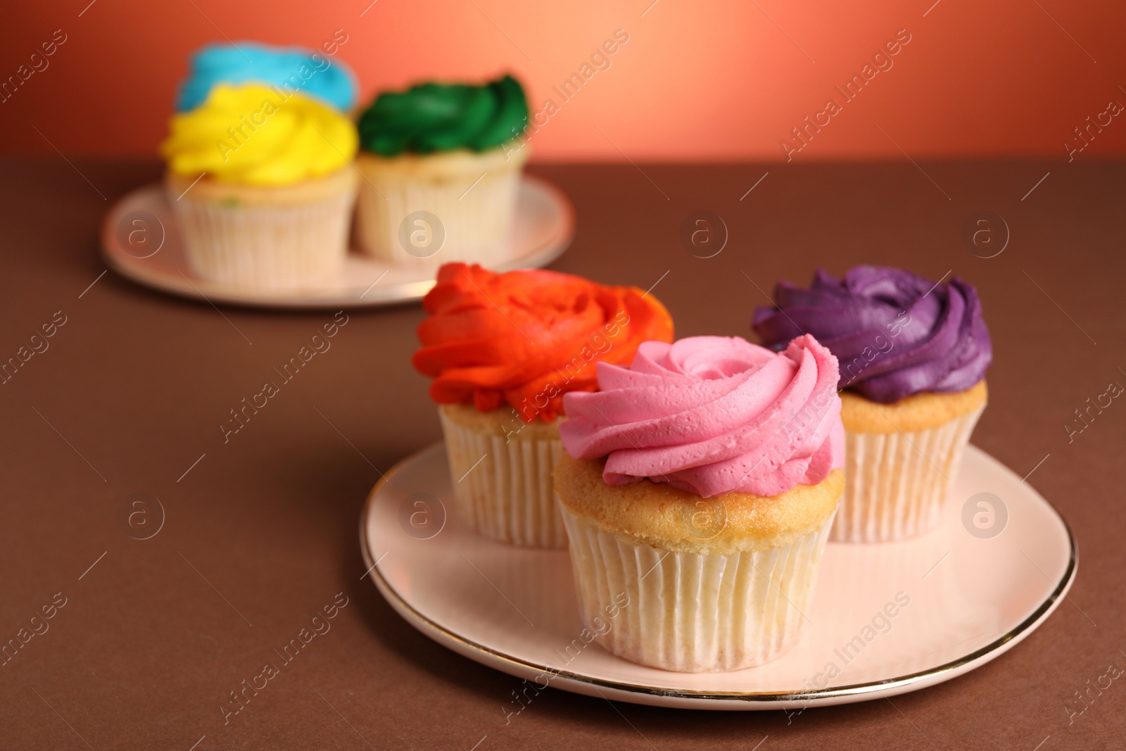 Photo of Delicious cupcakes with bright cream on color background