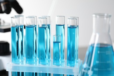 Photo of Test tubes with light blue liquid in laboratory, closeup