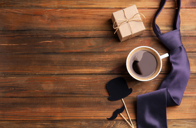 Photo of Flat lay composition with coffee and gift on wooden table, space for text. Happy Father's Day