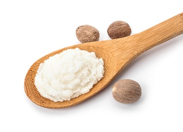 Spoon of shea butter and nuts on white background