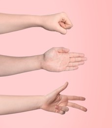 People playing rock, paper and scissors on pink background, closeup