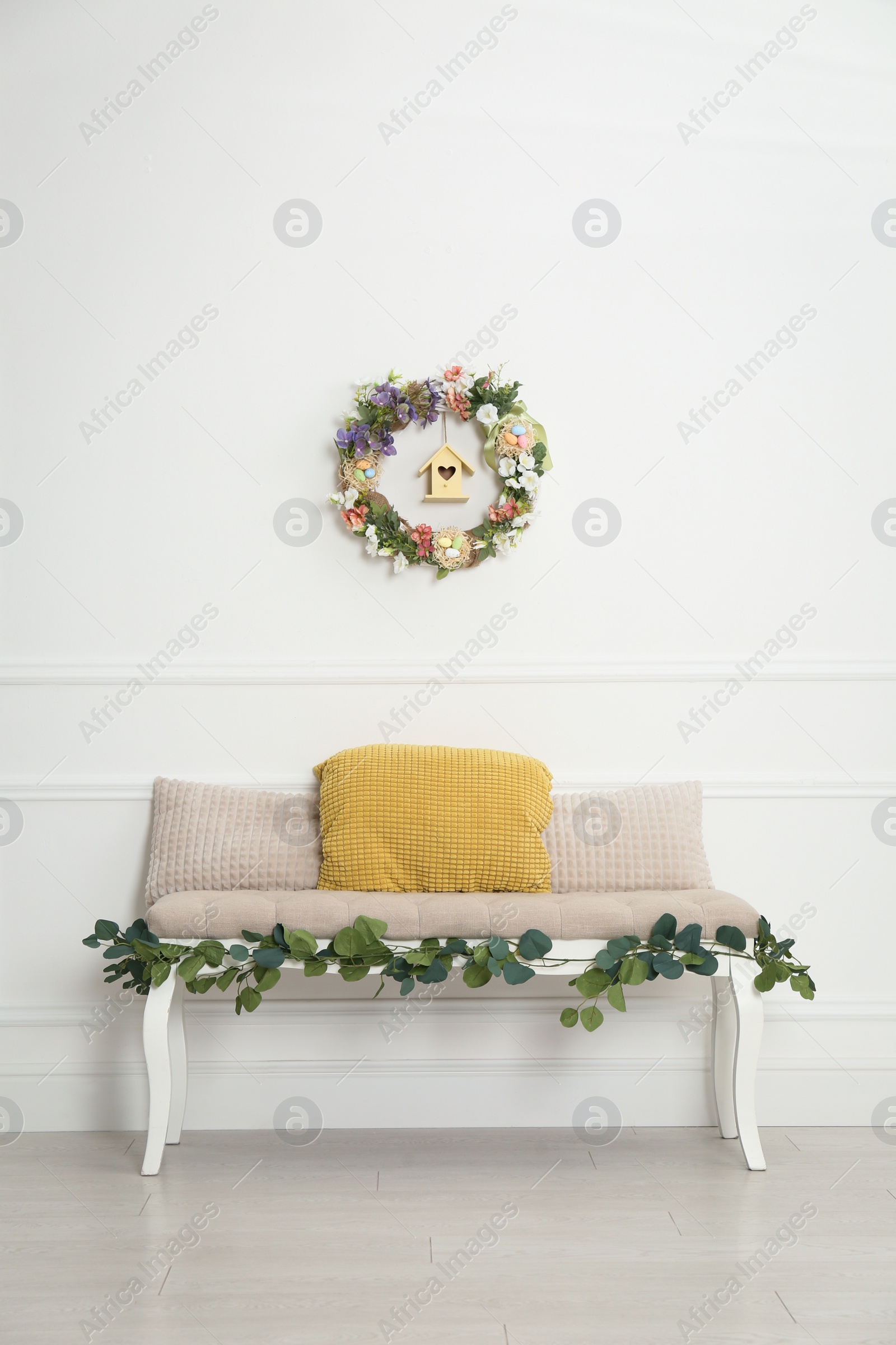 Photo of Elegant Easter photo zone with floral decor and bench indoors