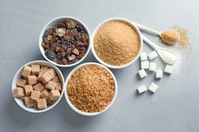 Photo of Flat lay composition with different types of sugar on gray background