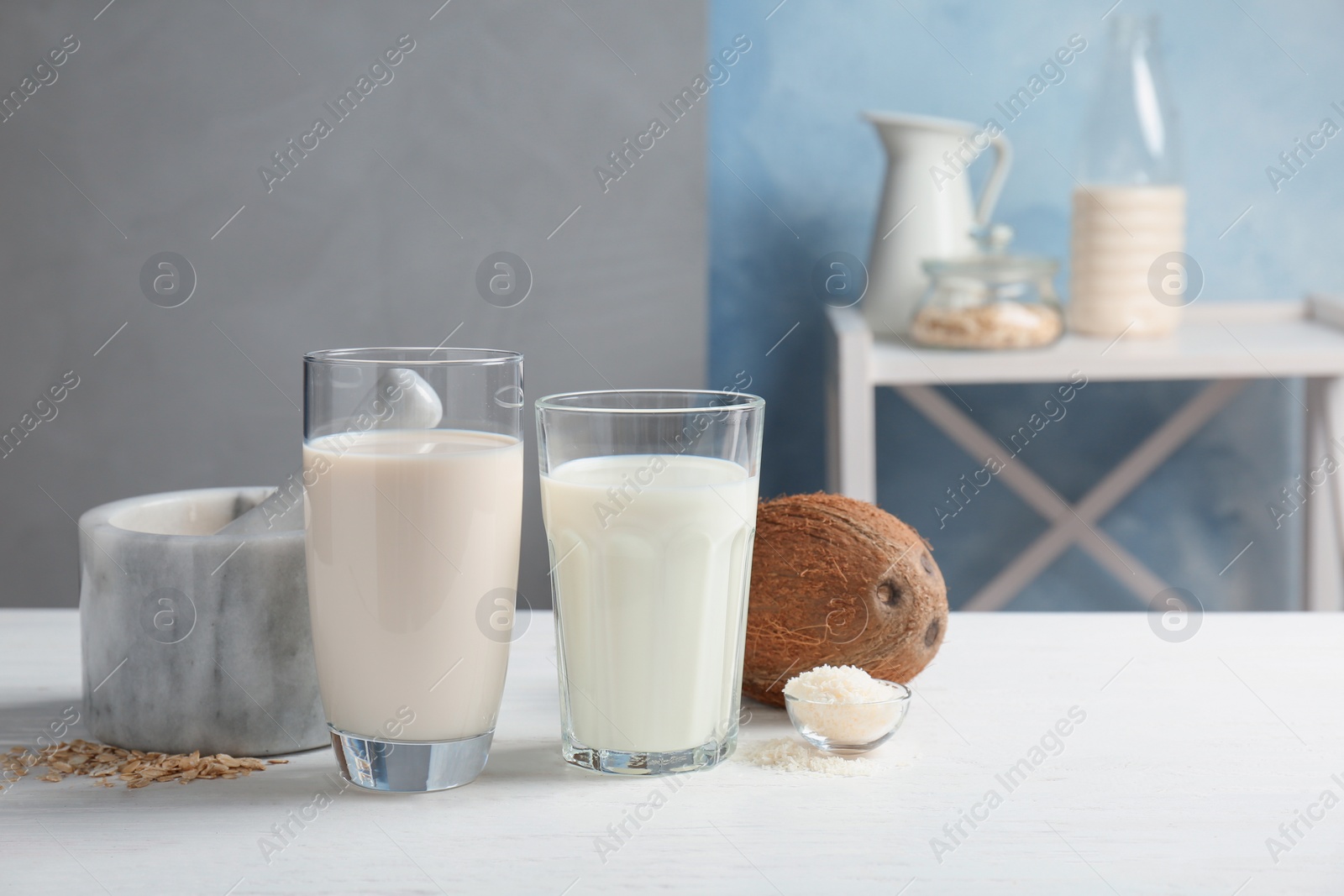 Photo of Glasses with coconut and oat milk on wooden table