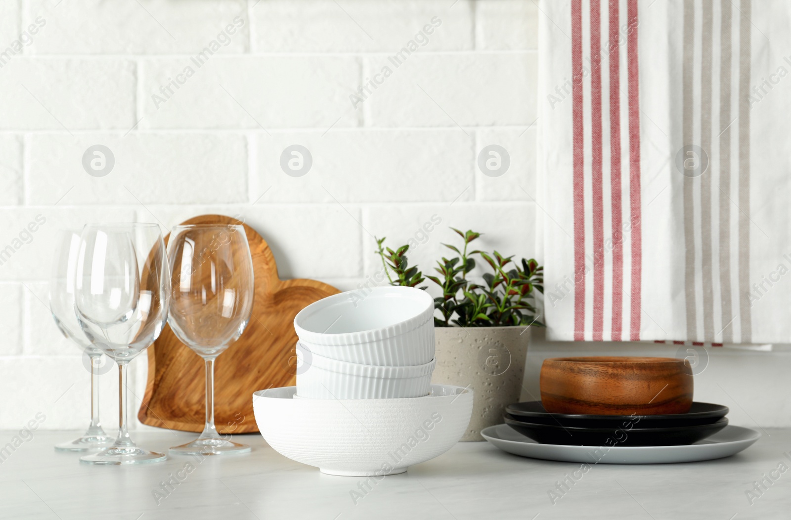 Photo of Set of clean tableware on white countertop in kitchen