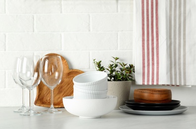 Set of clean tableware on white countertop in kitchen