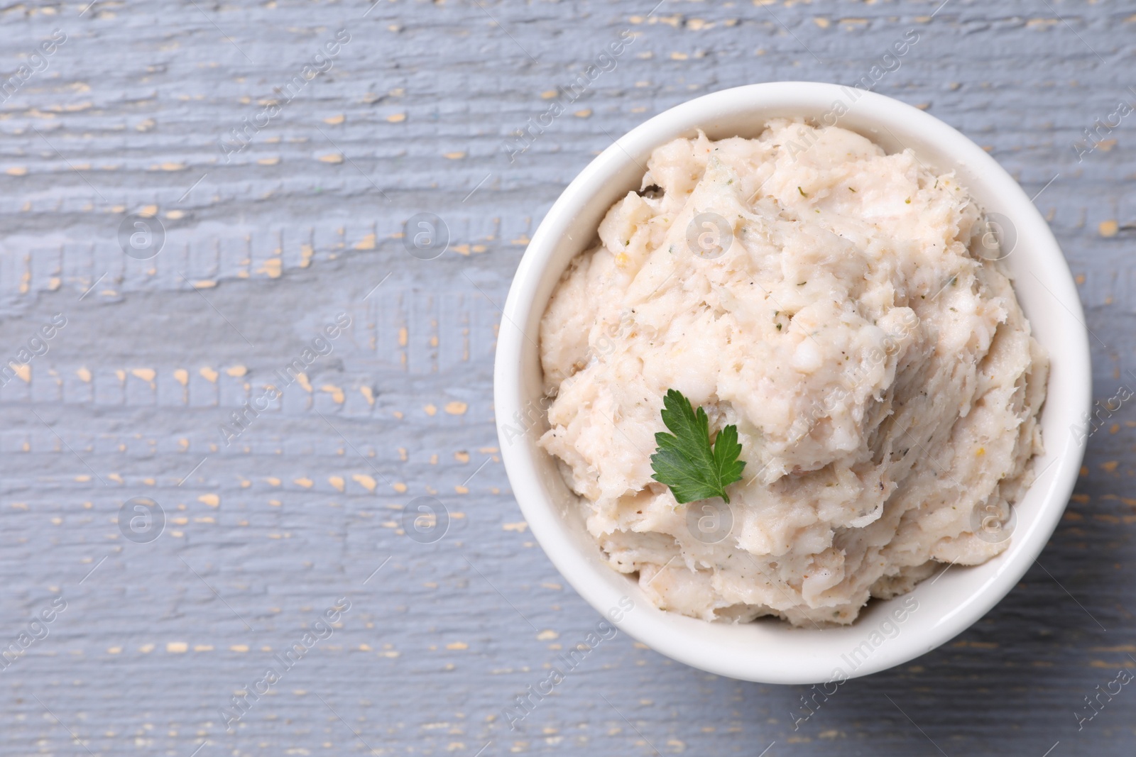 Photo of Lard spread in bowl on light grey wooden table, top view. Space for text