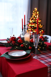 Photo of Table served for festive dinner and blurred Christmas tree in stylish room interior
