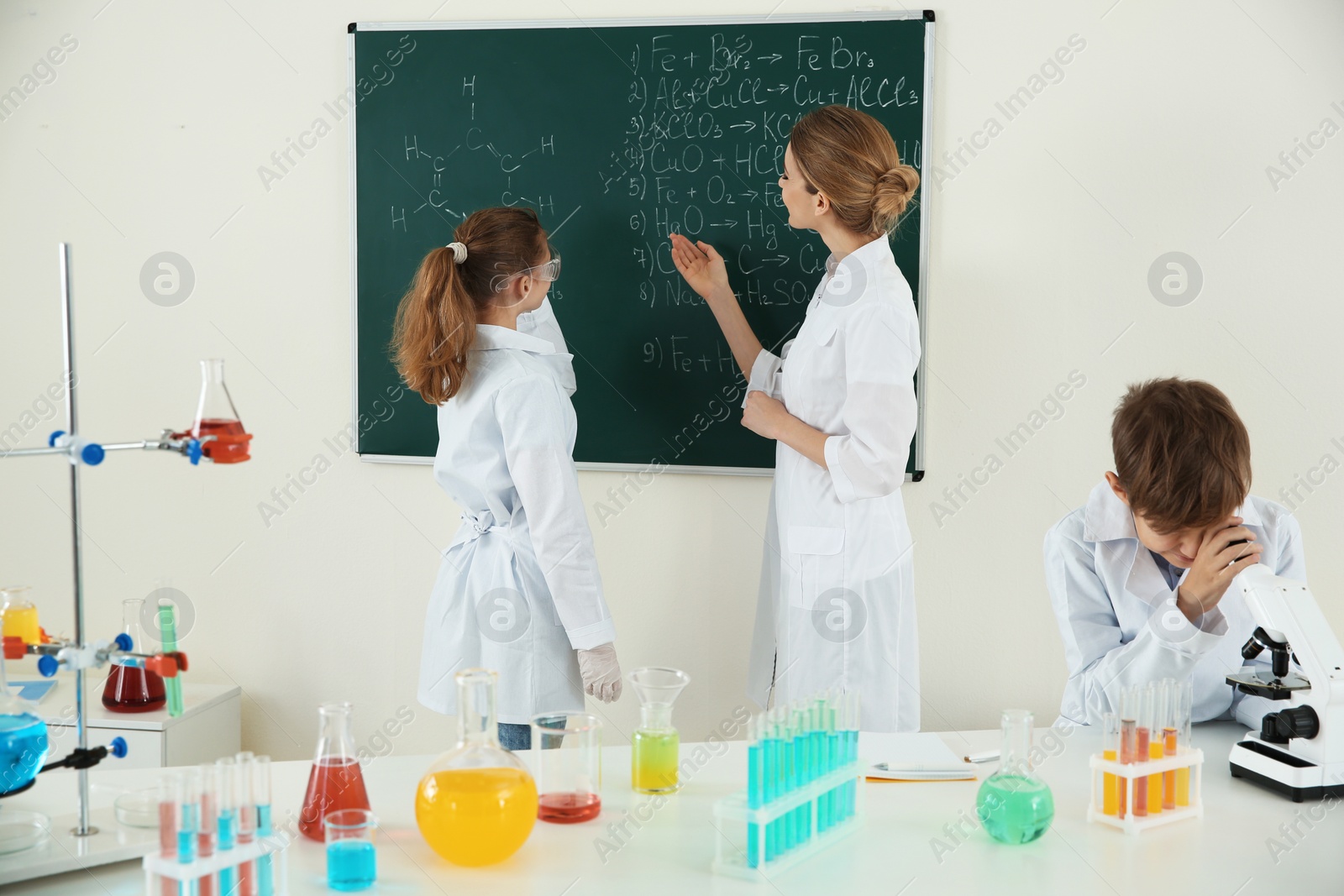 Photo of Teacher with pupils at chemistry lesson in classroom