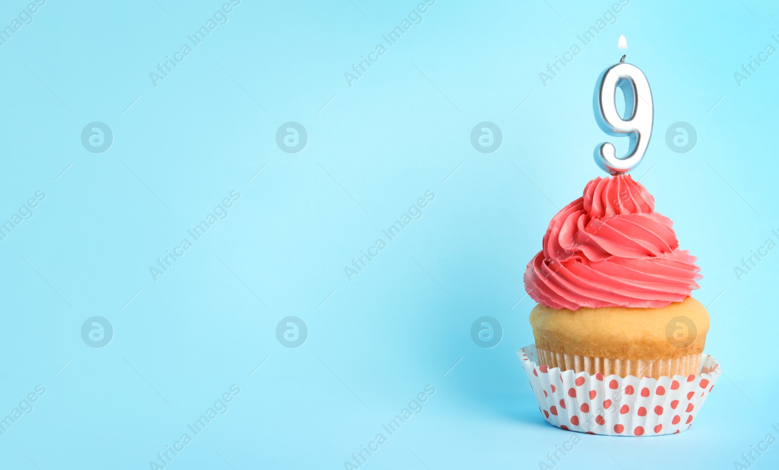 Photo of Birthday cupcake with number nine candle on blue background, space for text