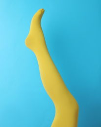 Photo of Leg mannequin in yellow tights on blue background