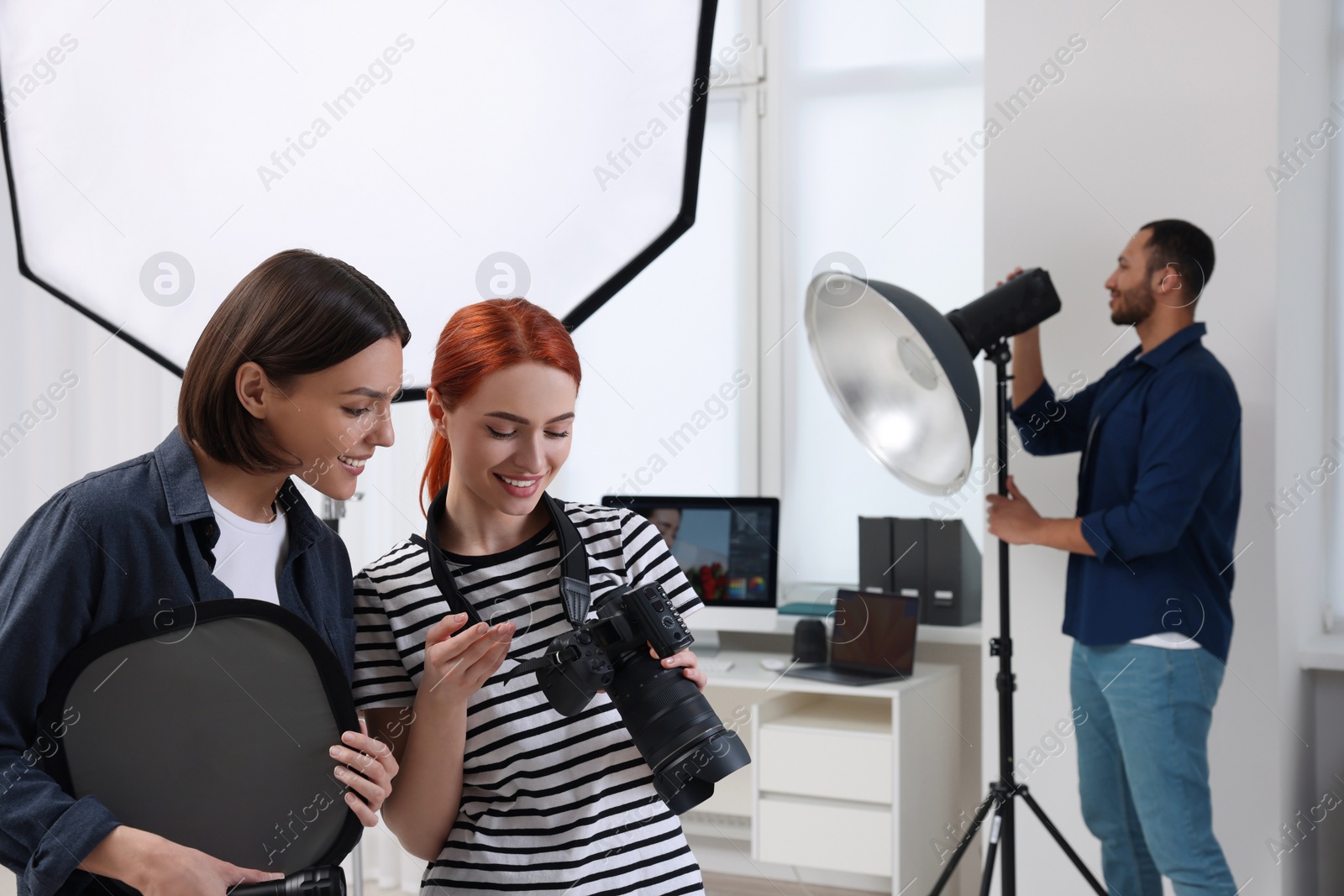 Photo of Young professional photographers working in modern photo studio