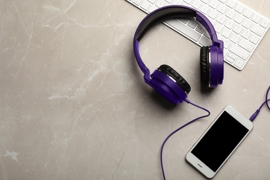 Photo of Flat lay composition with headphones, smartphone and keyboard on table. Space for text