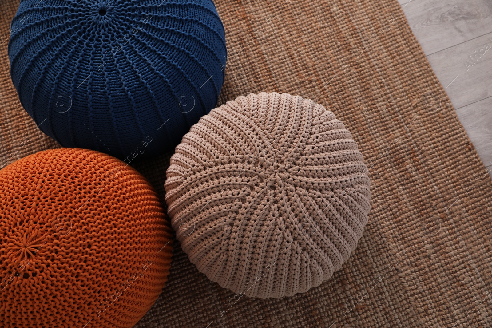 Photo of Stylish comfortable poufs on carpet, top view. Home design
