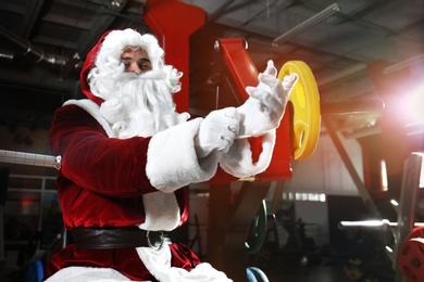 Young Santa Claus wearing gloves in modern gym