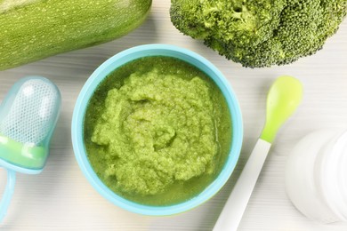 Photo of Healthy baby food. Bowl with delicious broccoli puree and ingredients on white wooden table, flat lay