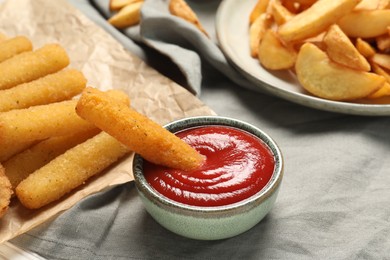 Photo of Delicious cheese sticks and ketchup on table, closeup