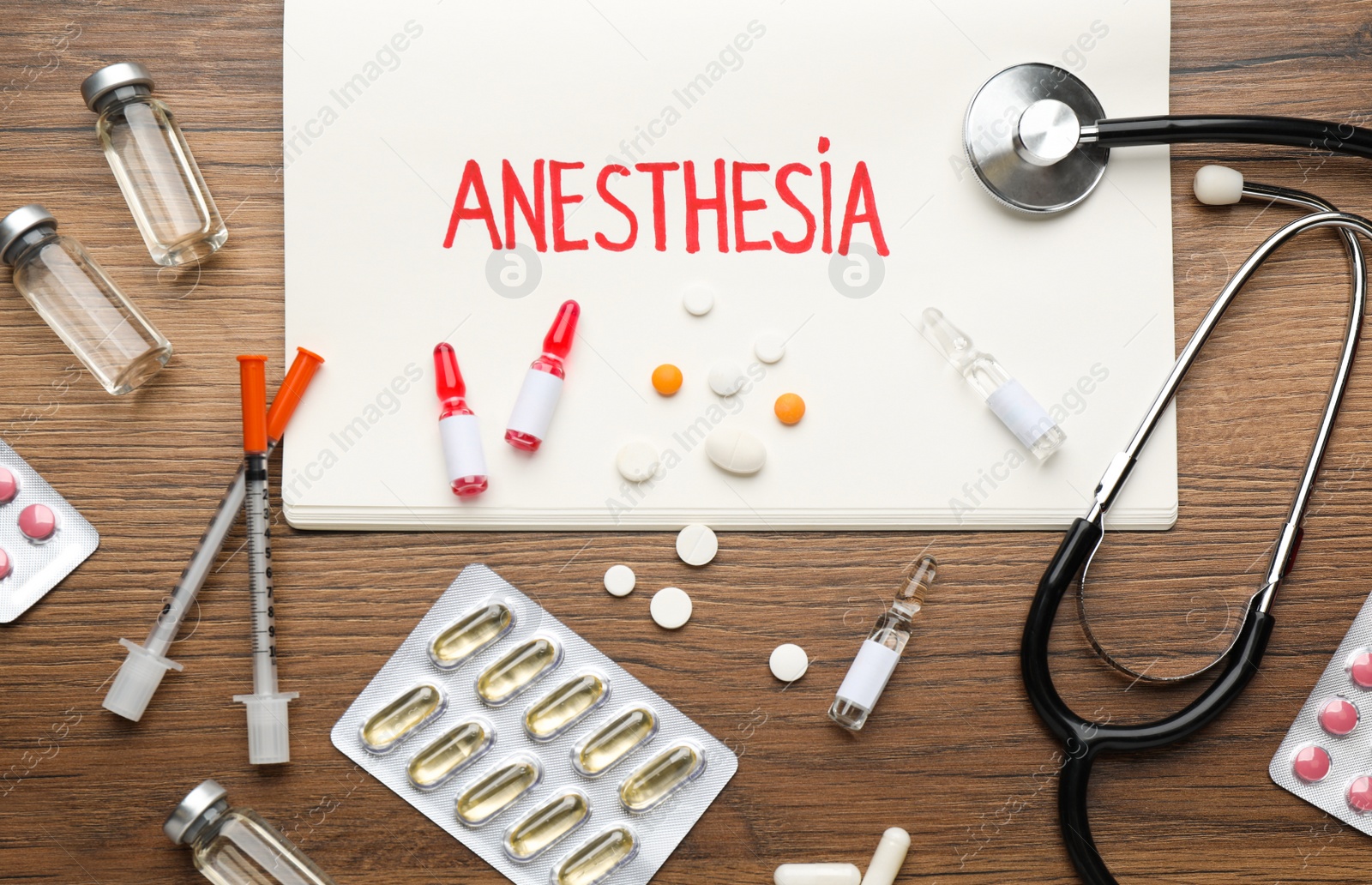 Photo of Flat lay composition of notebook with word Anesthesia and drugs on wooden table