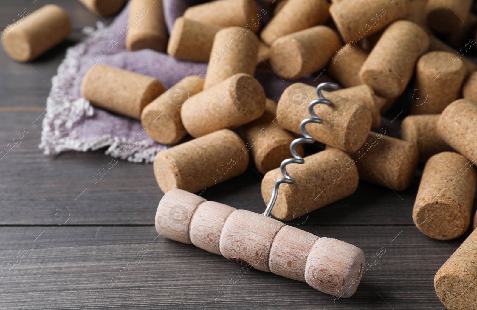 Photo of Corkscrew and wine bottle stoppers on wooden table, closeup