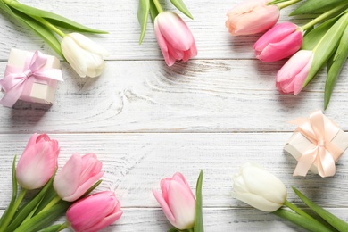 Photo of Flat lay composition of beautiful spring tulips on wooden background, space for text. International Women's Day