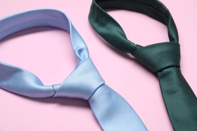 Photo of Two neckties on pink background, closeup view