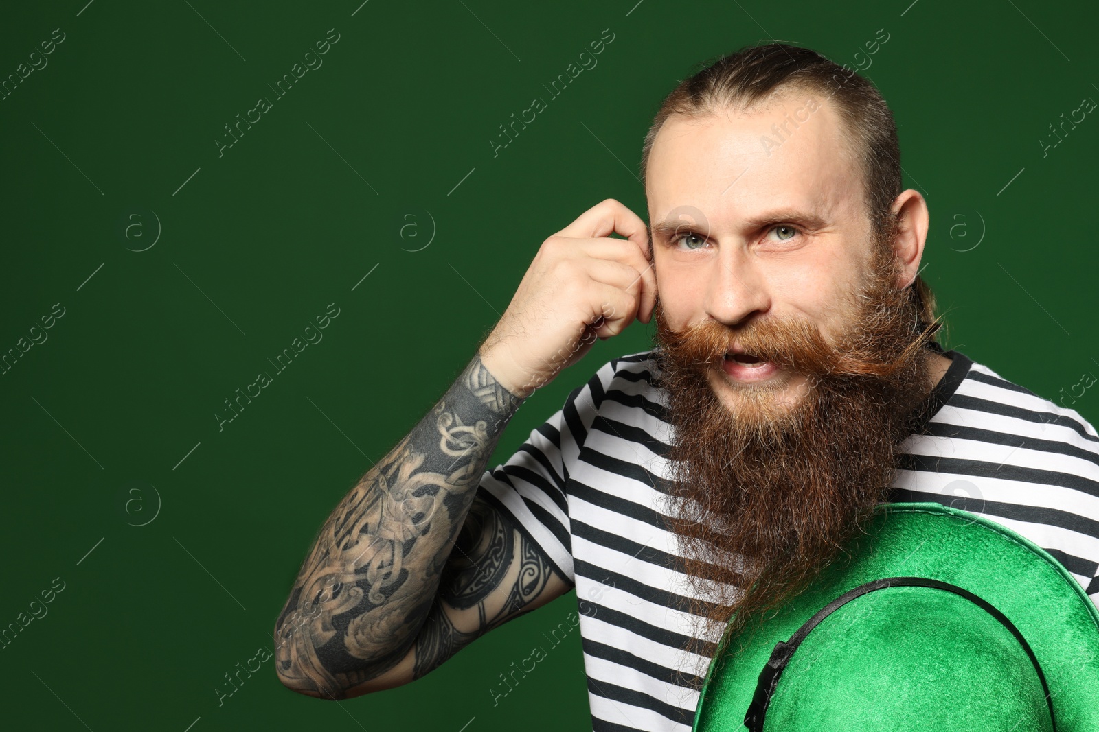 Photo of Bearded man with green hat on color background. St. Patrick's Day celebration