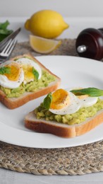 Photo of Tasty sandwiches with boiled egg, avocado and spinach on table