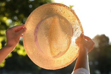 Photo of Young woman with straw hat outdoors on sunny day, closeup