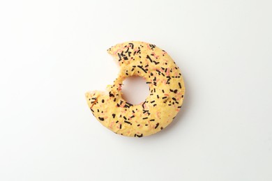 Delicious yellow glazed donut with bite mark on white background, top view