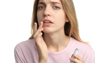 Photo of Woman with herpes applying cream onto lip against white background