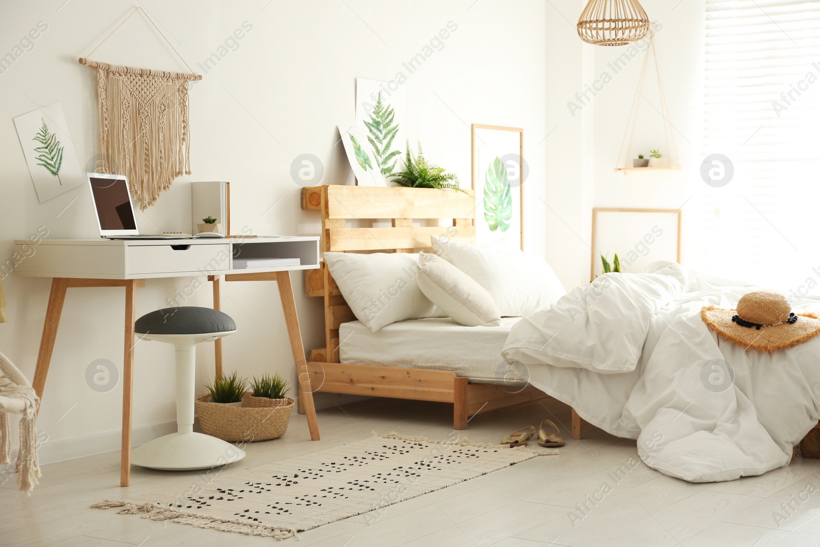 Photo of Stylish room interior with workplace and bed