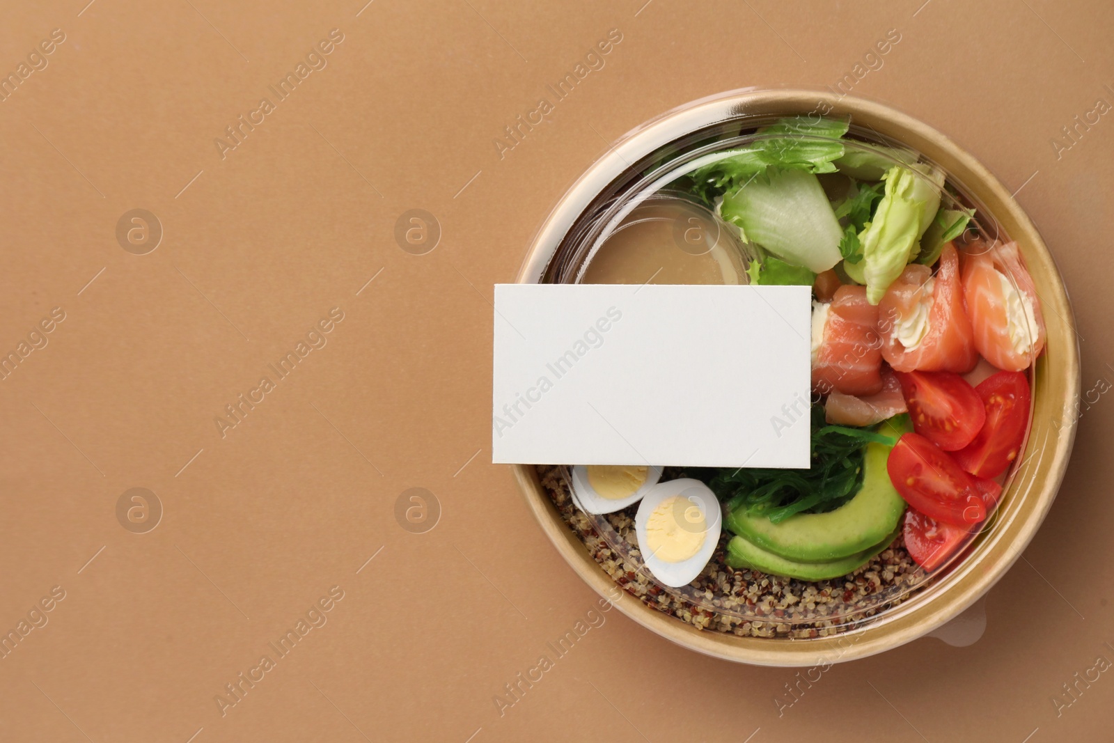 Photo of Tasty food in container on beige background, top view. Space for text