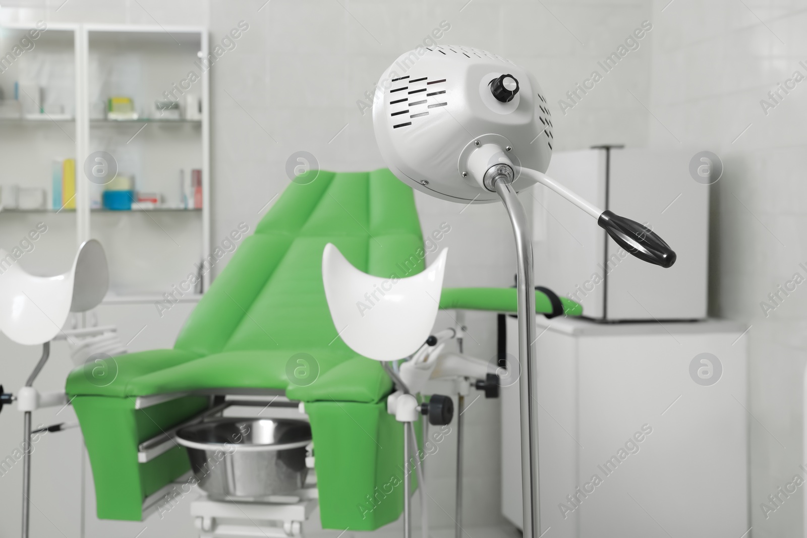 Photo of Examination room with gynecological chair and medical equipment in clinic