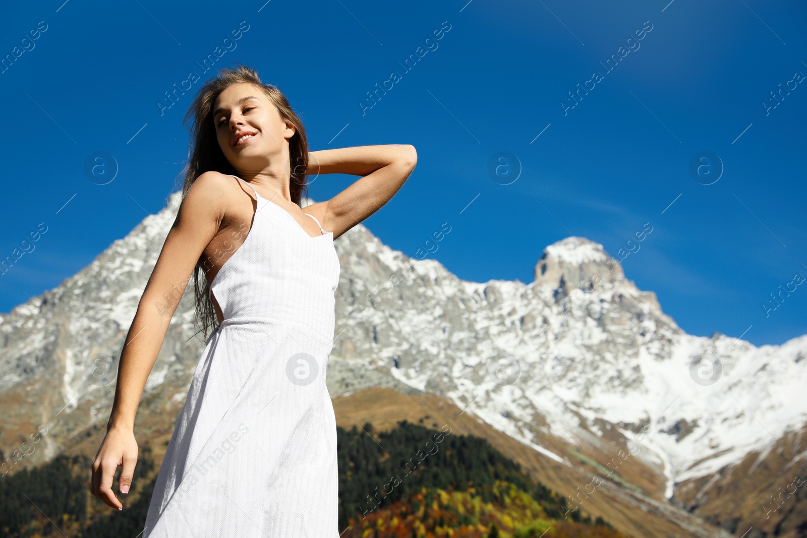 Photo of Young woman walking in beautiful mountains on sunny day. Space for text