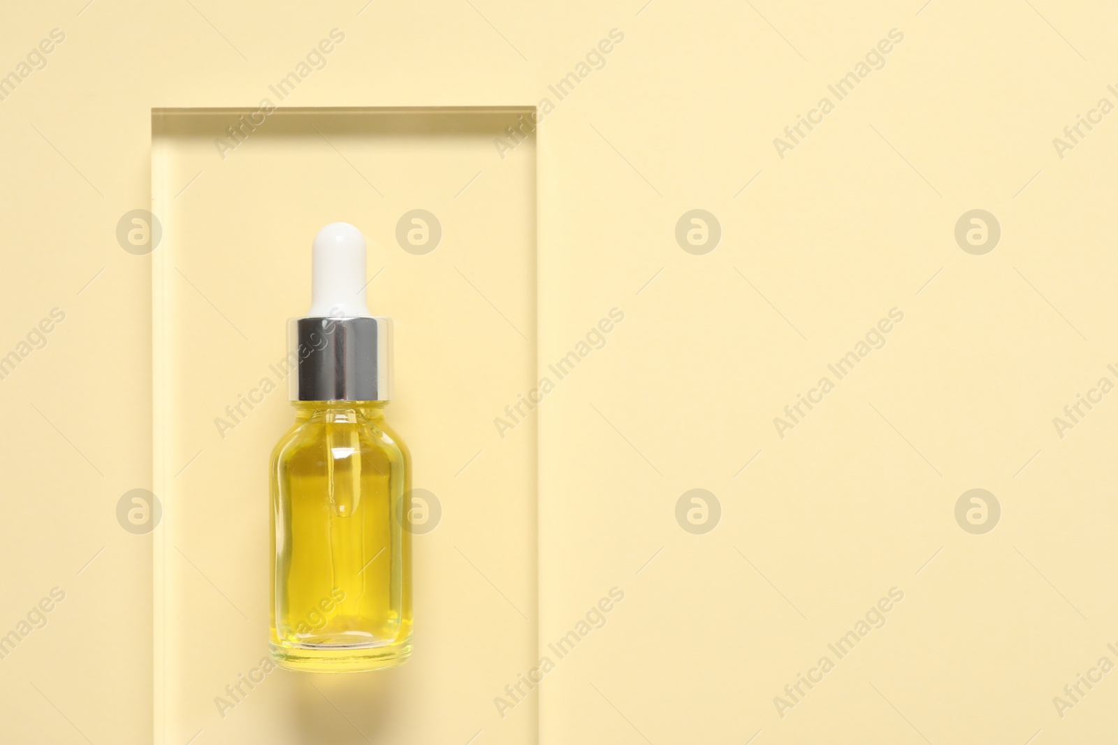 Photo of Bottle of cosmetic serum on beige background, top view. Space for text