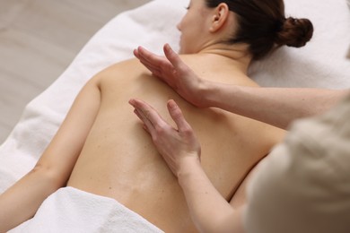 Photo of Woman receiving back massage on couch in spa salon, closeup