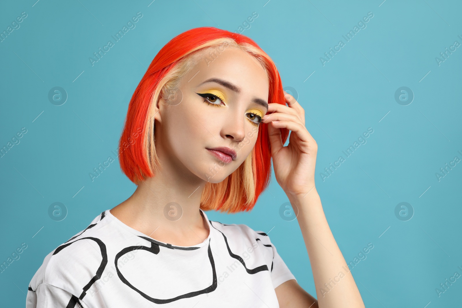 Photo of Beautiful young woman with bright dyed hair on turquoise background