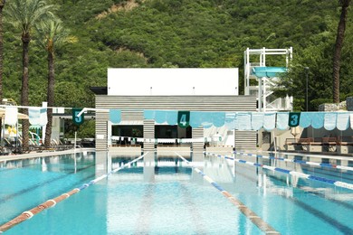 Photo of Outdoor swimming pool and tropical plants at luxury resort on sunny day