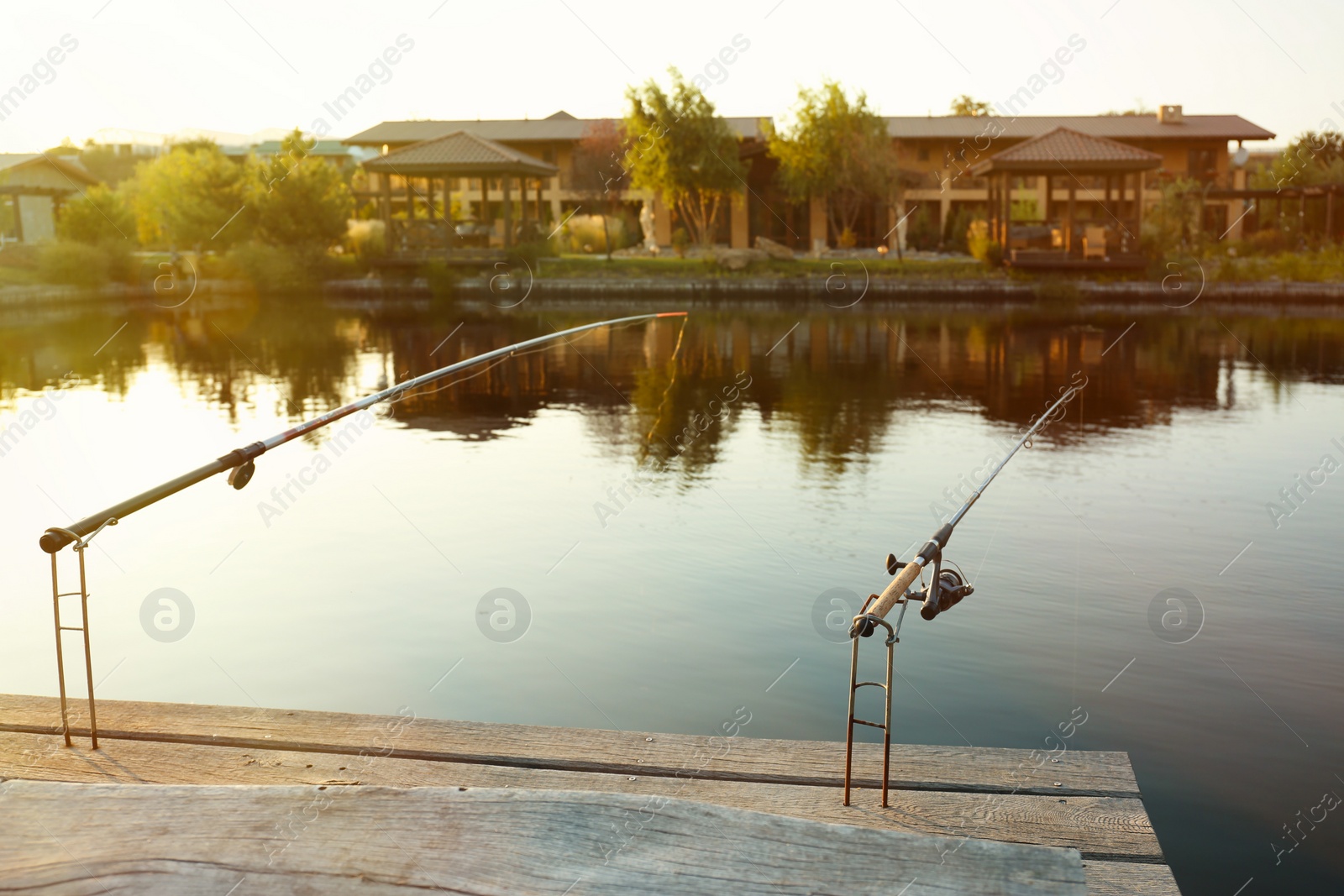 Photo of Fishing rods on wooden pier at lake