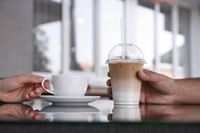 Photo of Man and woman with coffees at table in outdoor cafe, closeup