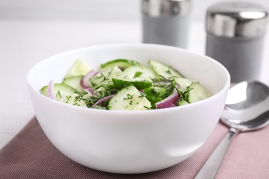 Photo of Delicious fresh cucumber onion salad in bowl served on table