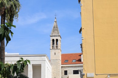 Photo of View of beautiful old buildings against light blue sky